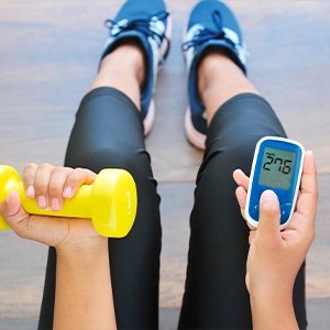Person holding a light dumbbell during a home workout as part of a daily glucose wellness routine